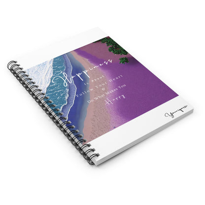 Spiral notebook with purple beach graphic with quote Happiness Is About Follow Your Heart And Do What Makes You Happy on table by Youniqverse