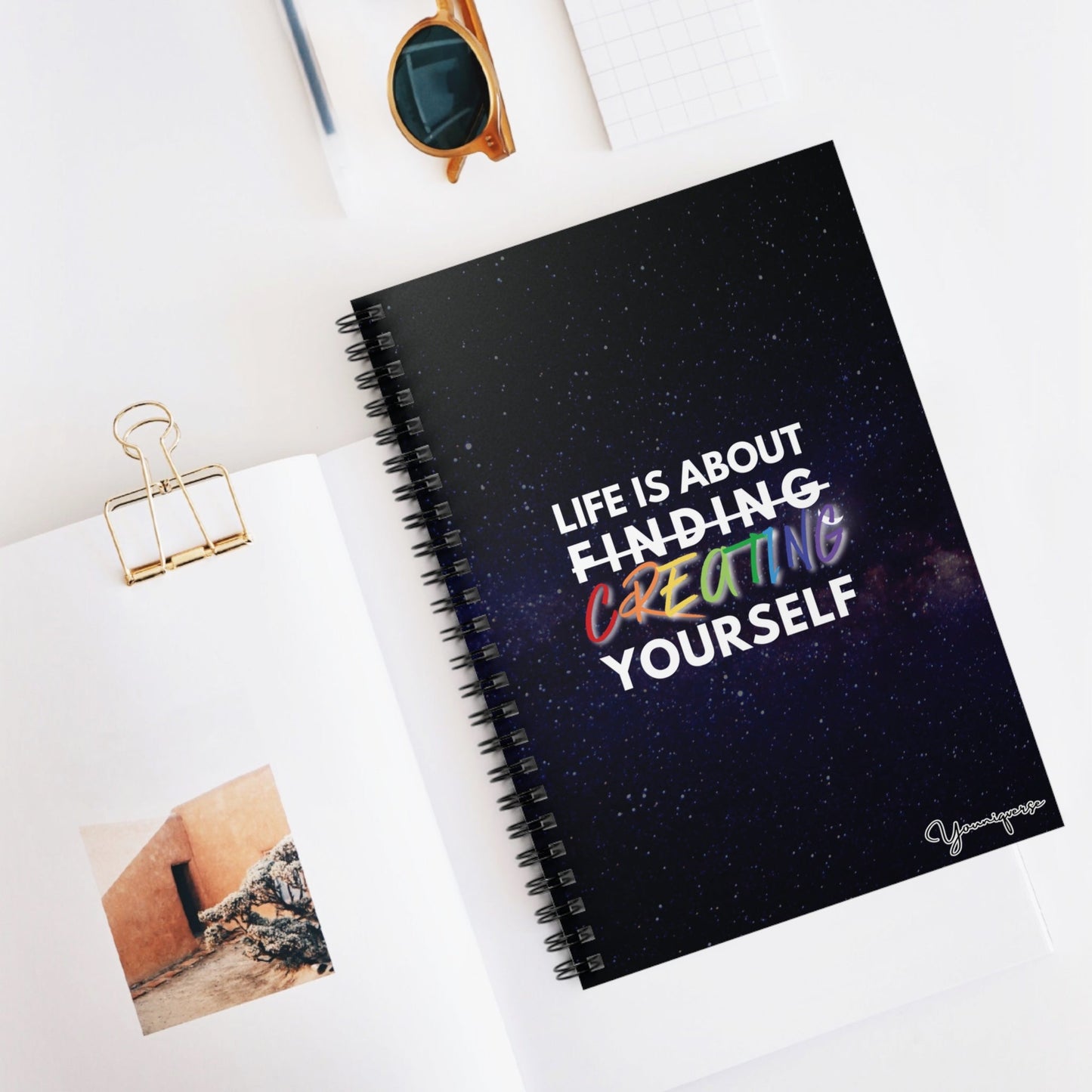 Spiral Notebook with universe background with inspiring quote Life is About Finding Creating Yourself on table 2 by Youniqverse