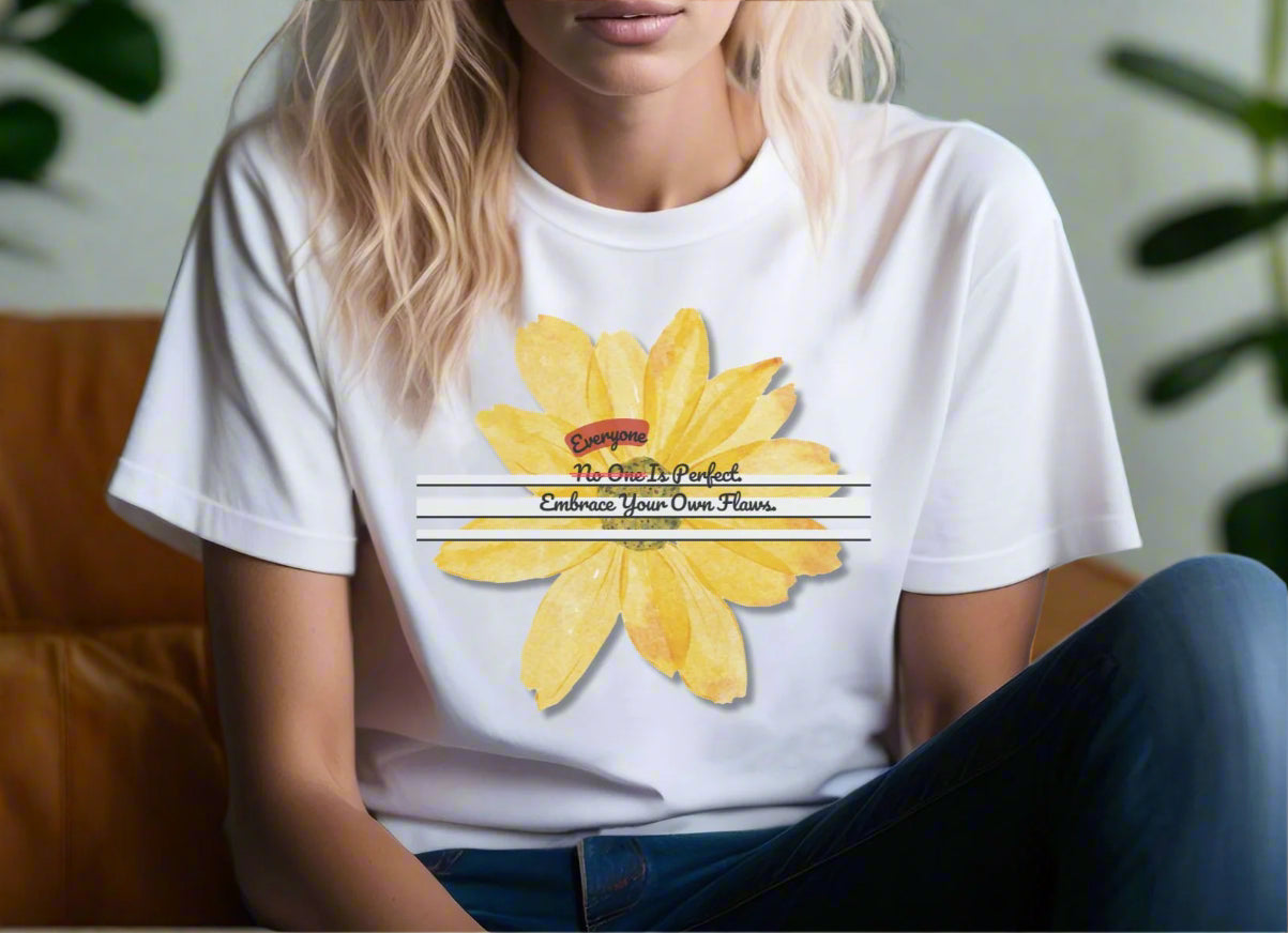 A woman sitting on sofa wearing white unisex t-shirt with floral graphic Everyone Is Perfect Embrace Your Own Flaws by Youniqverse